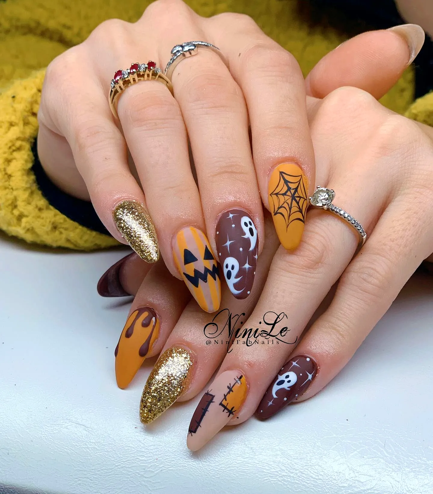 Cute stiletto fall nail designs with Halloween art in warm orange and brown tones