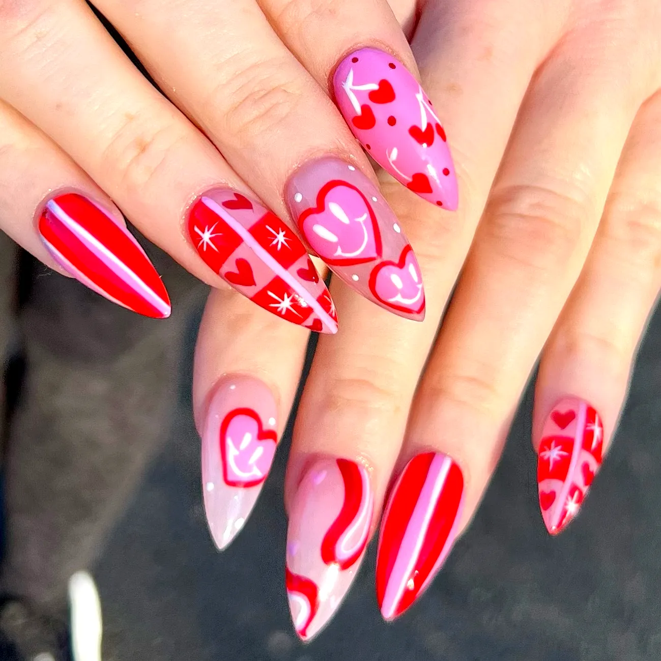 Cute Stiletto Valentines Day Nails in Pink and Red with Playful Heart Patterns and Whimsical Designs