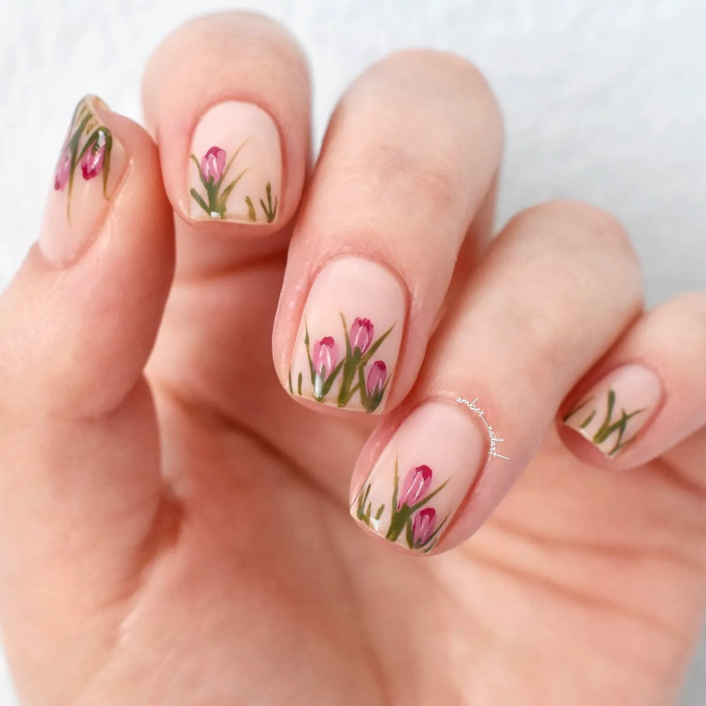 Cute tulip nail designs with soft pink color and delicate floral artwork on natural nail shape