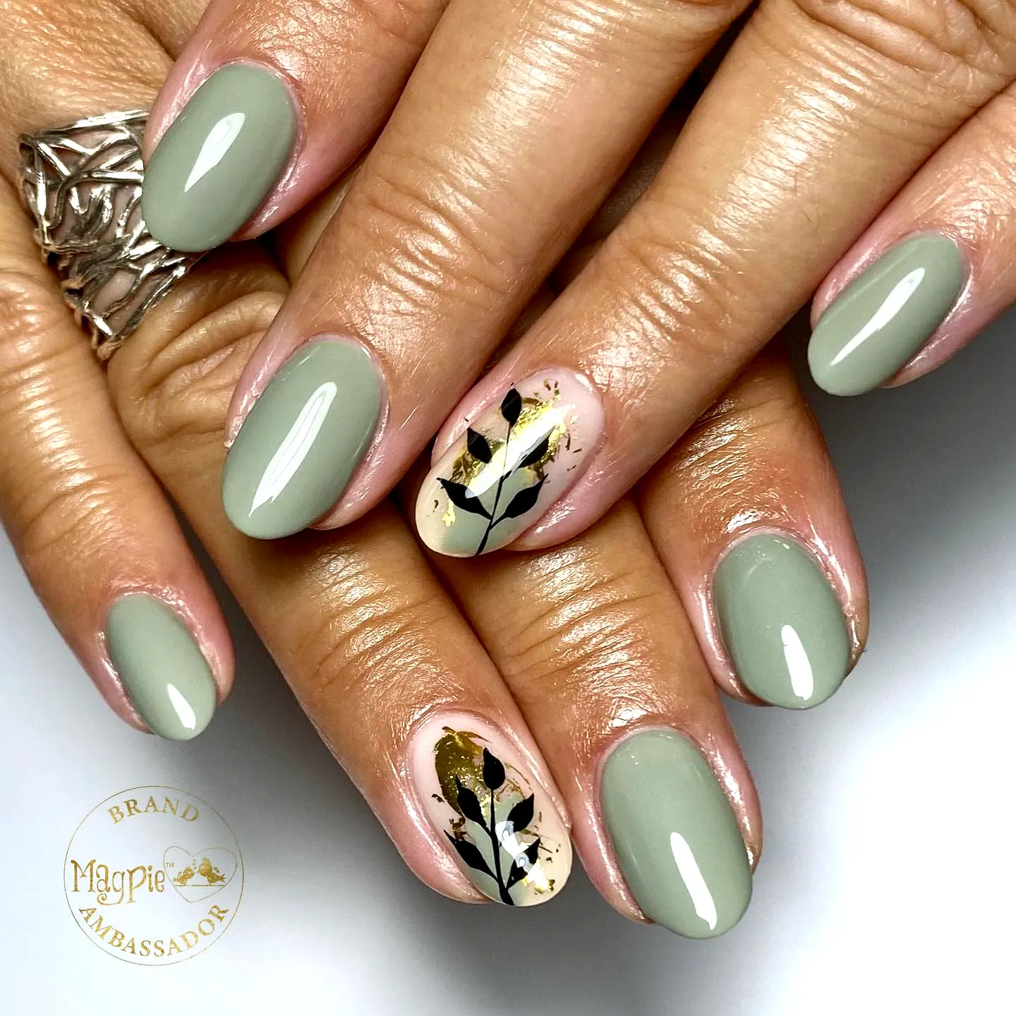 Elegant almond leaf nail designs in muted green with black and gold accents