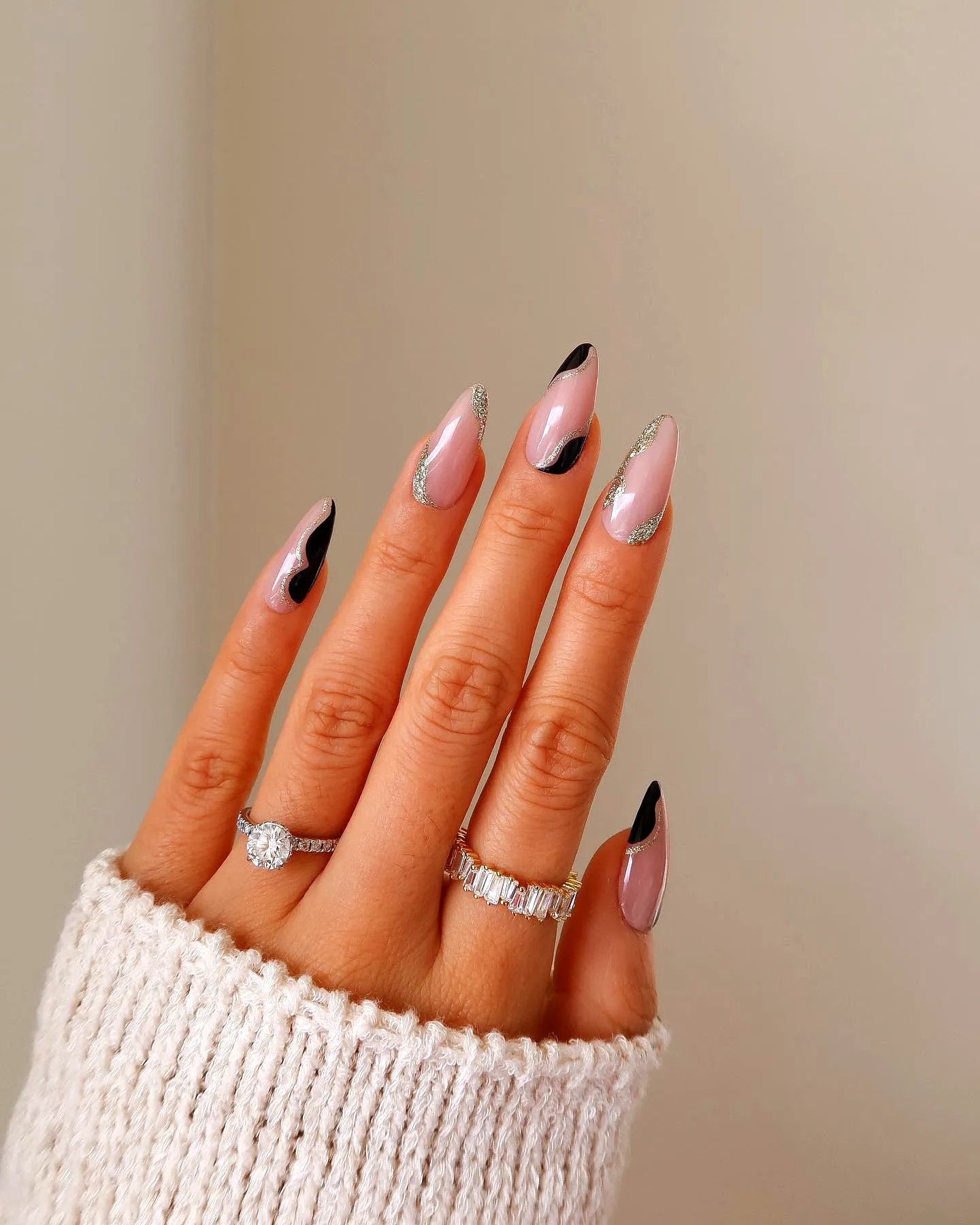 Elegant almond-shaped classy nail designs with soft pink base glossy black tips and sparkling silver glitter