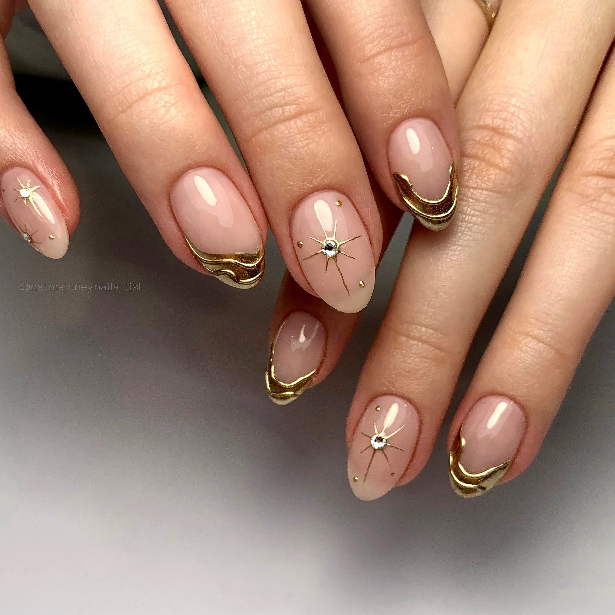 Elegant almond shaped gold chrome nails with nude color and chic French tips