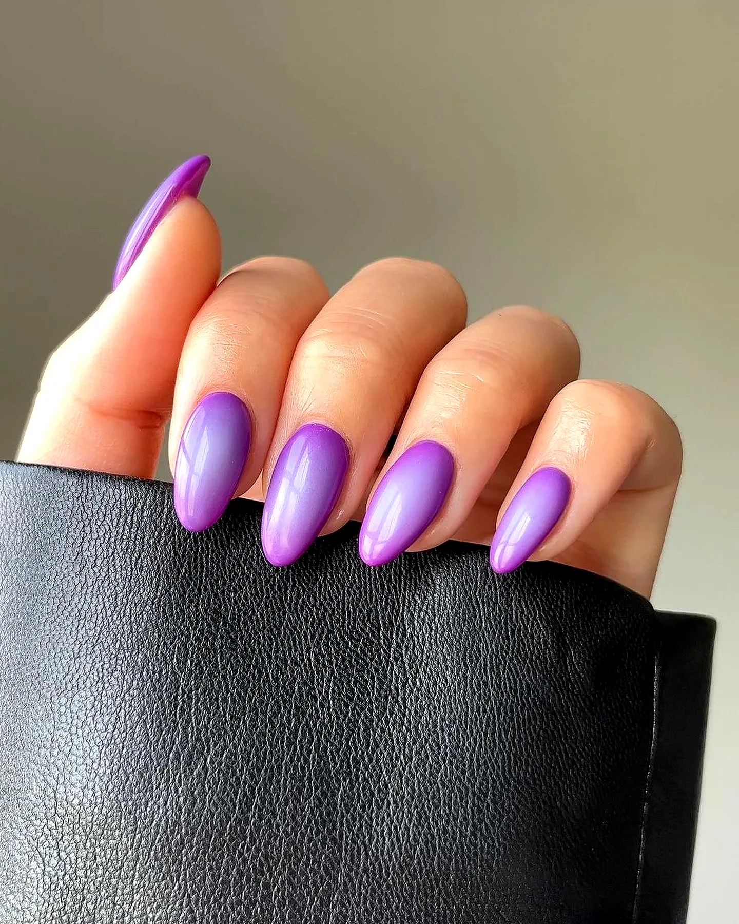 Elegant almond-shaped purple nails with stunning gradient design and glossy finish