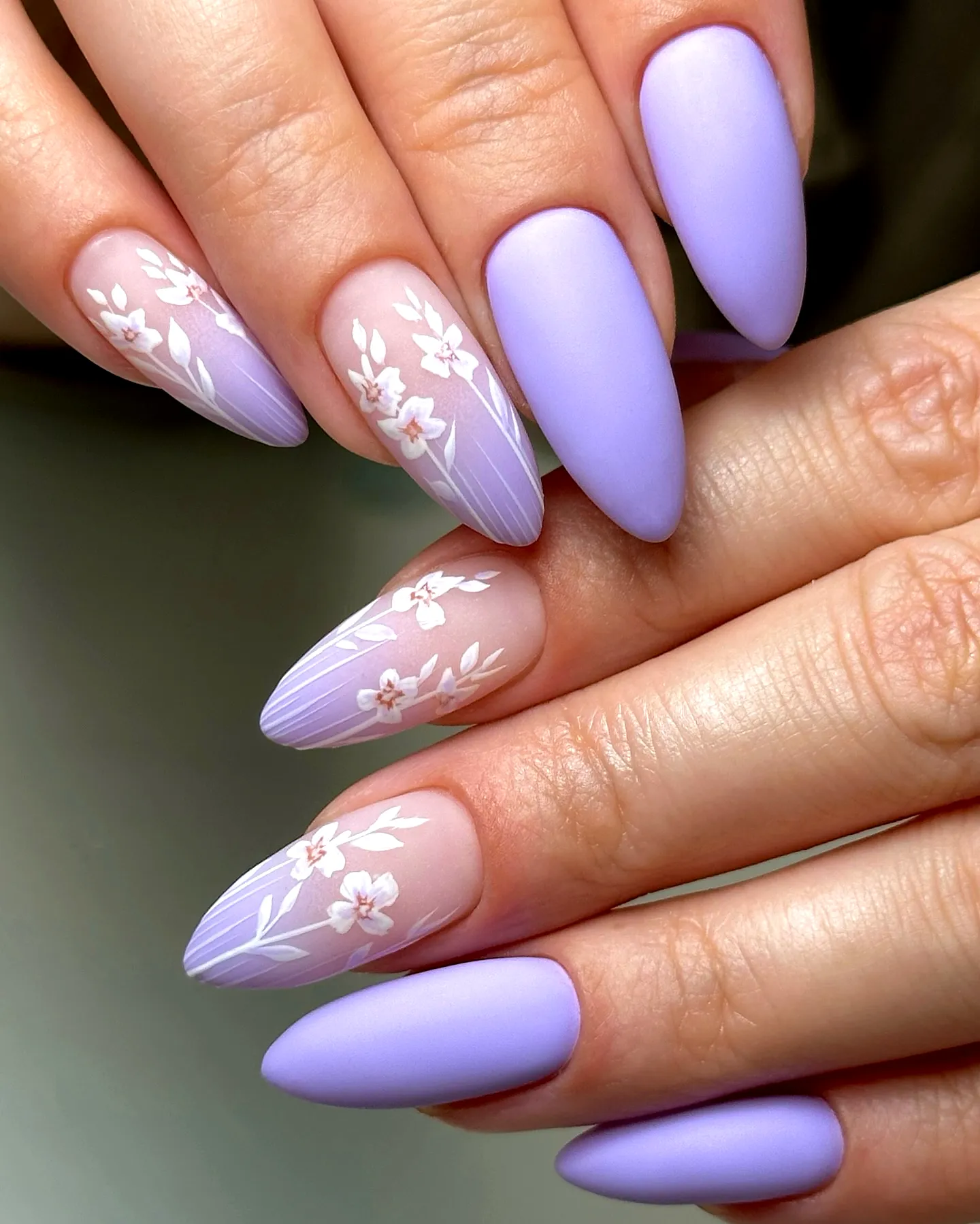 Elegant almond-shaped purple spring nails with floral accents and matte finishes