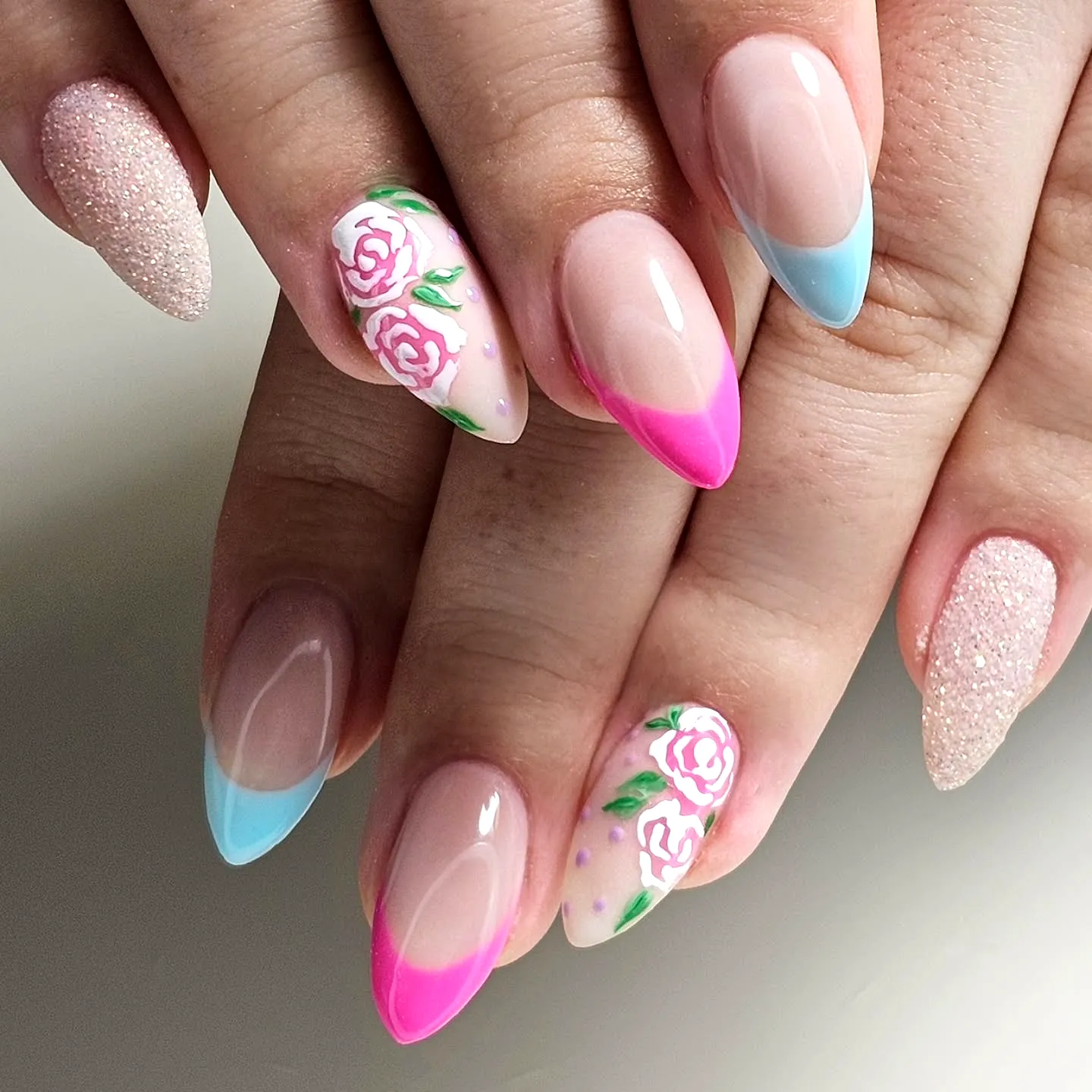 Elegant almond-shaped spring classy nails with pastel colors floral art and glitter gradient