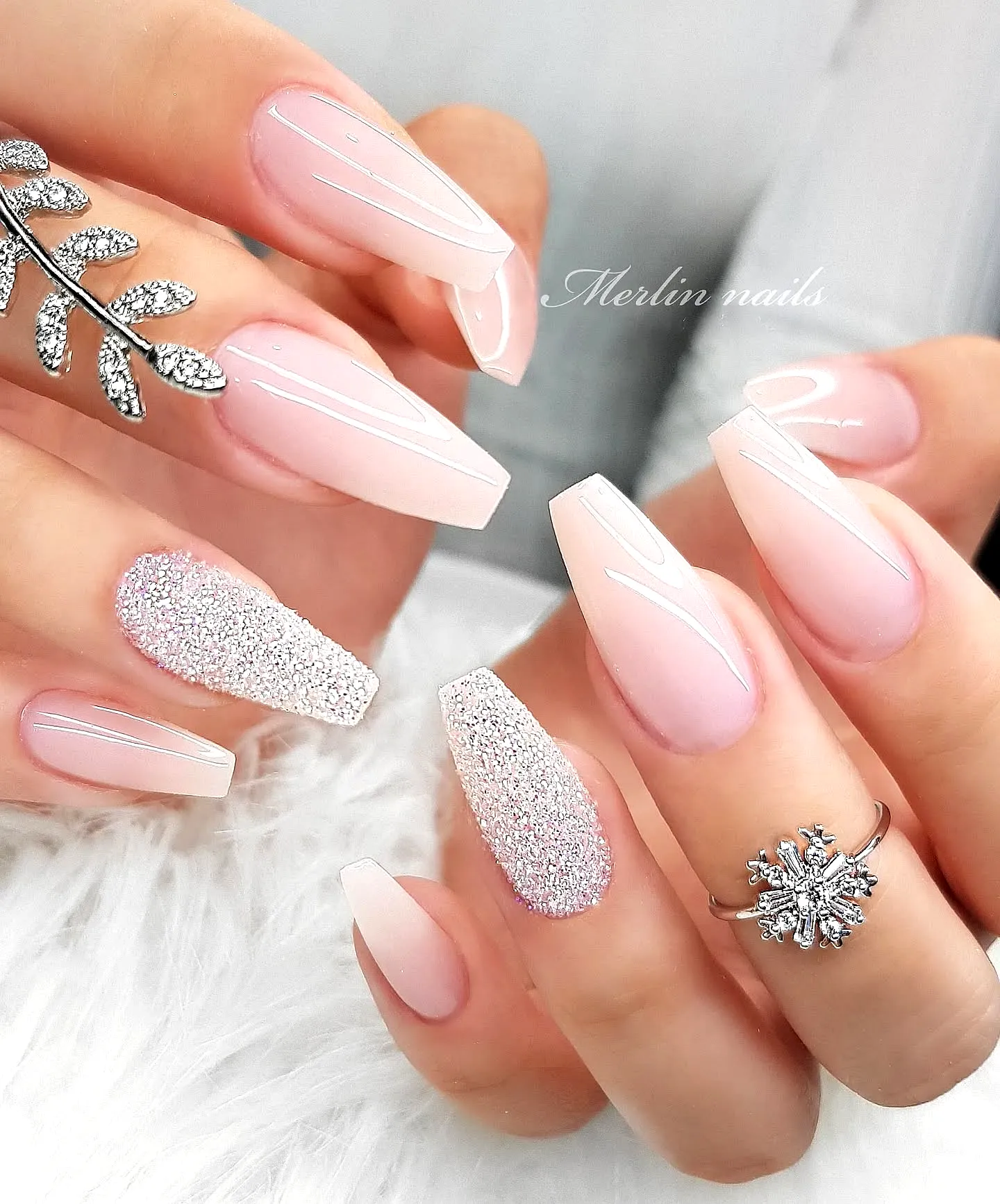 Elegant almond-shaped wedding nails in soft blush pink with sparkling glitter accents