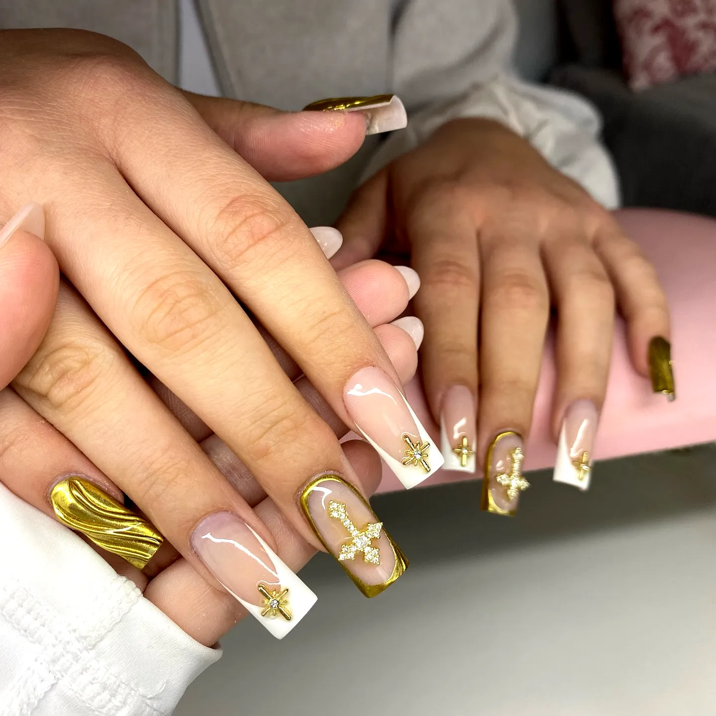 Elegant gold chrome nails showcase elongated square and stiletto shapes with chic marble effect and star motifs