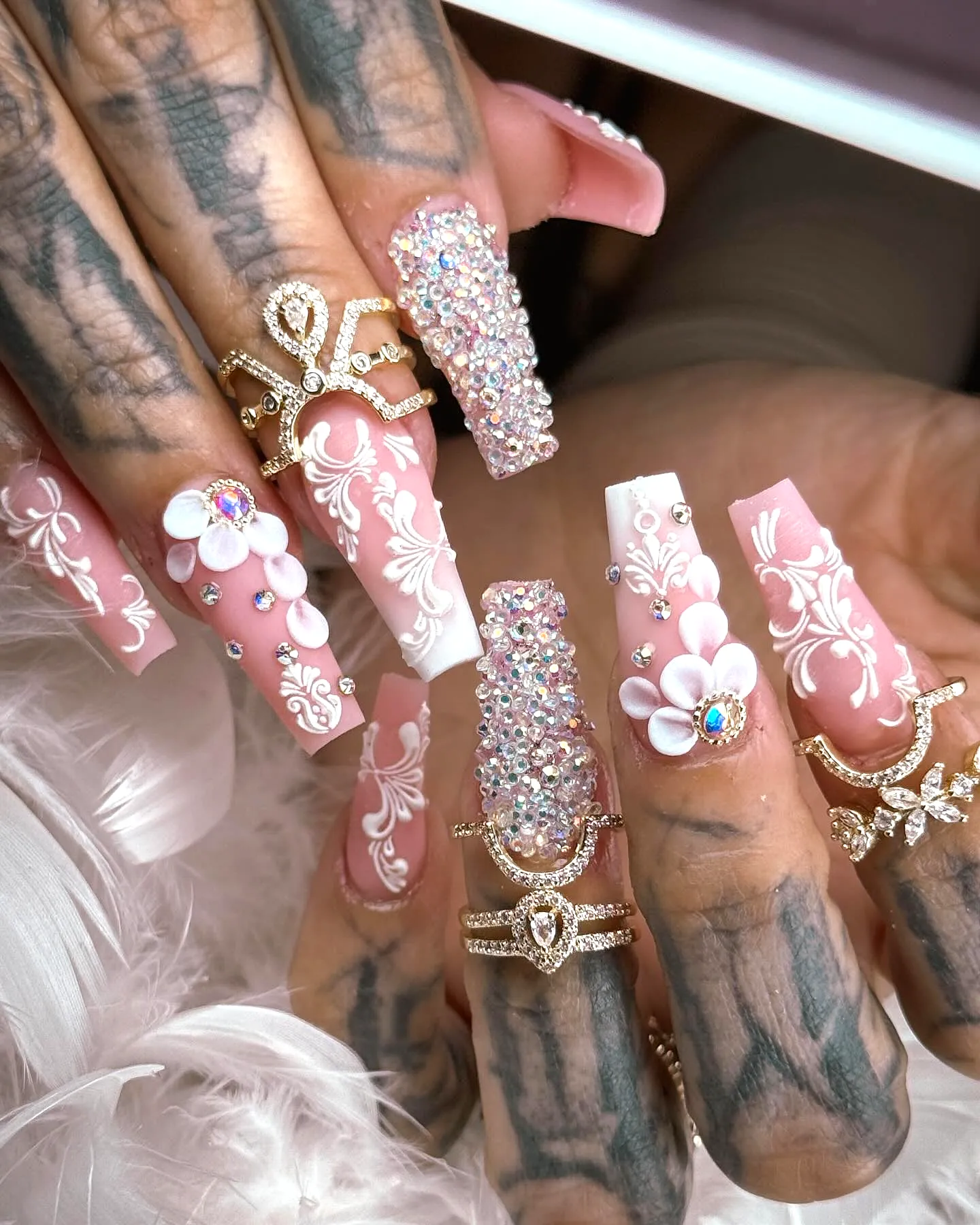 Elegant Long Square Wedding Nails with Soft Pink Color Intricate White Floral Patterns and Glamorous Rhinestones