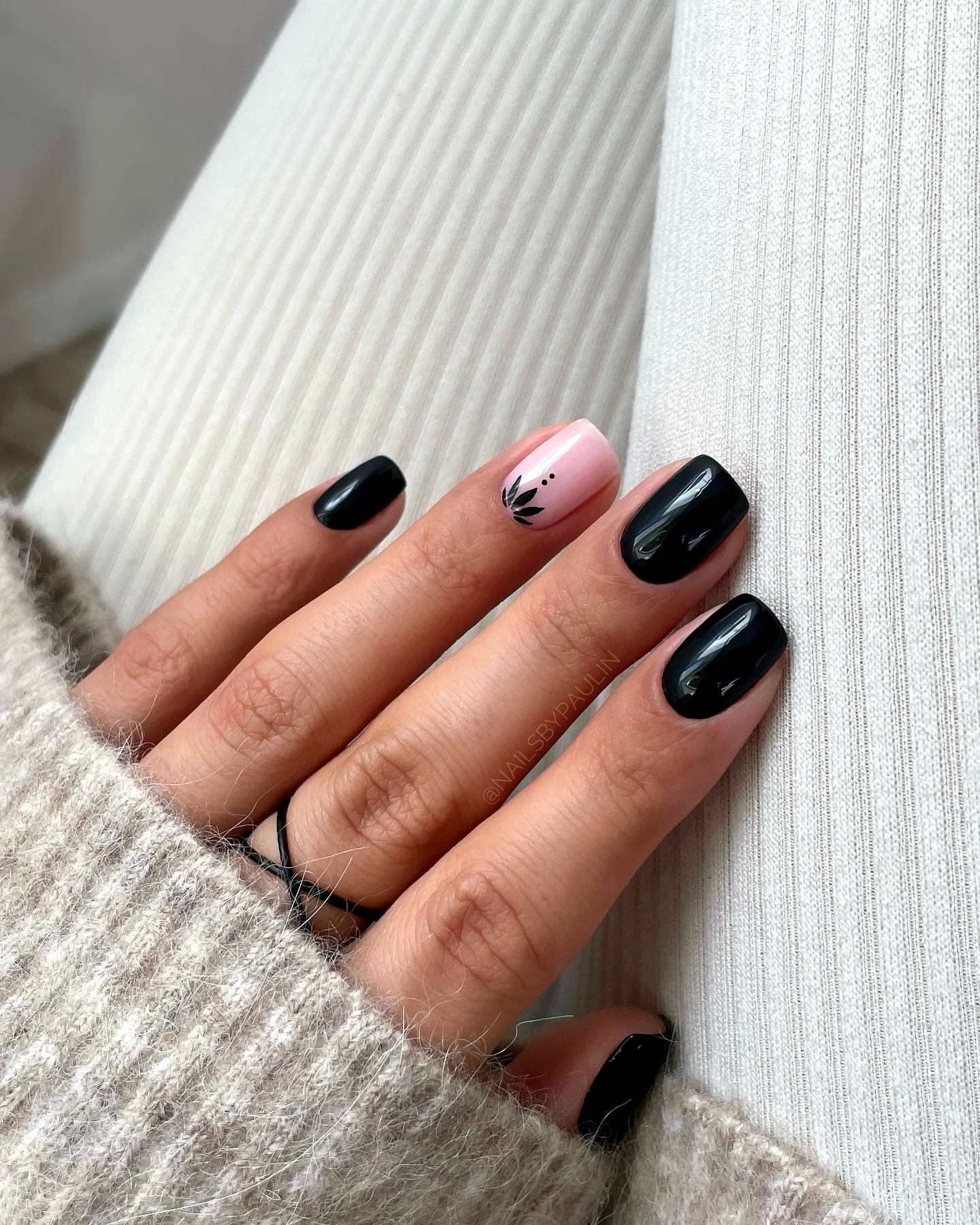Elegant Rounded Black Nails with Delicate Floral Art and Soft Pink Accents