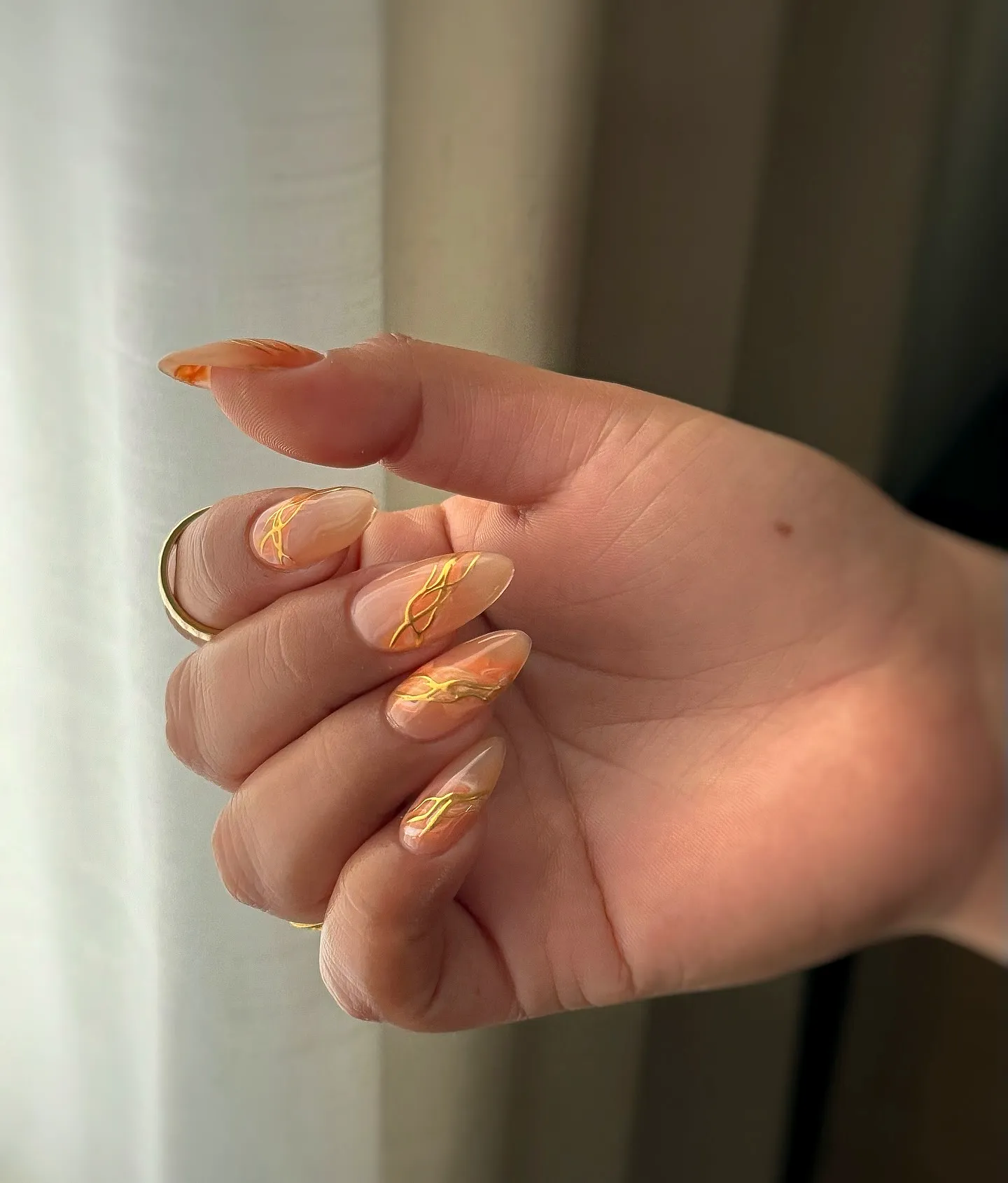 Elegant stiletto spring classy nails with marbled orange and gold patterns