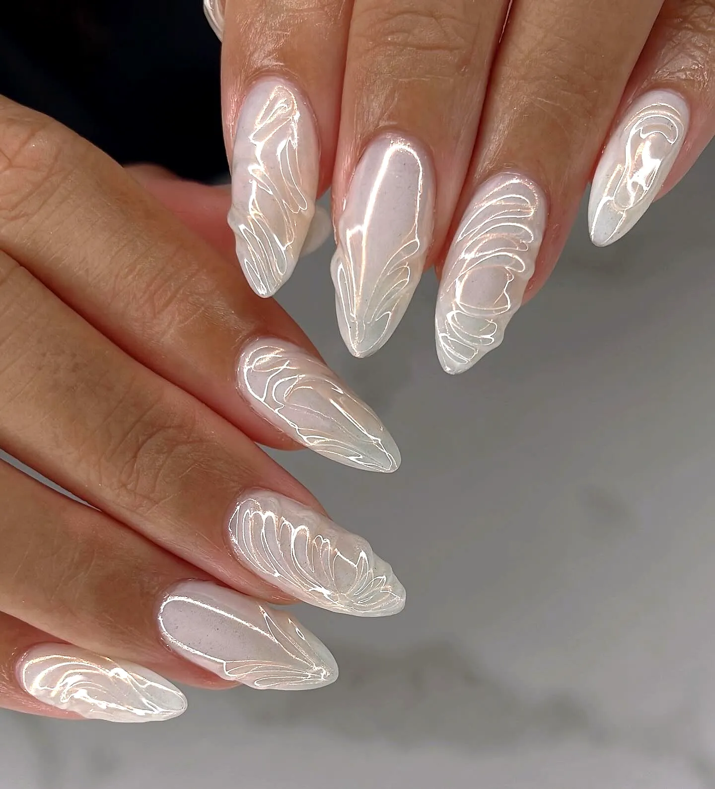 Elegant stiletto wedding nails with translucent glossy base and delicate feather patterns