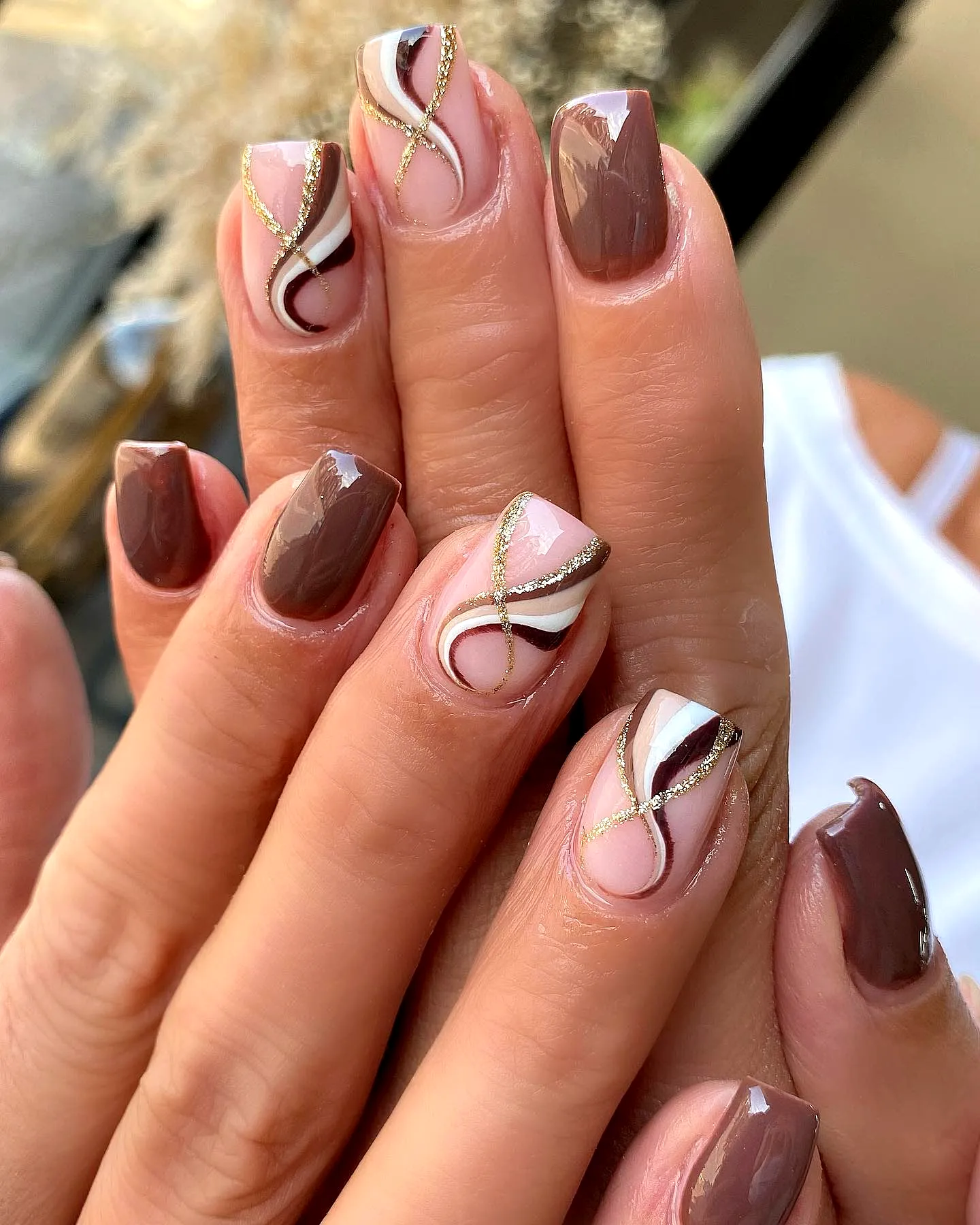 Elegant Swirl Nail Designs with Square and Rounded Shapes in Rich Brown and Soft Beige Accented with Gold Glitter