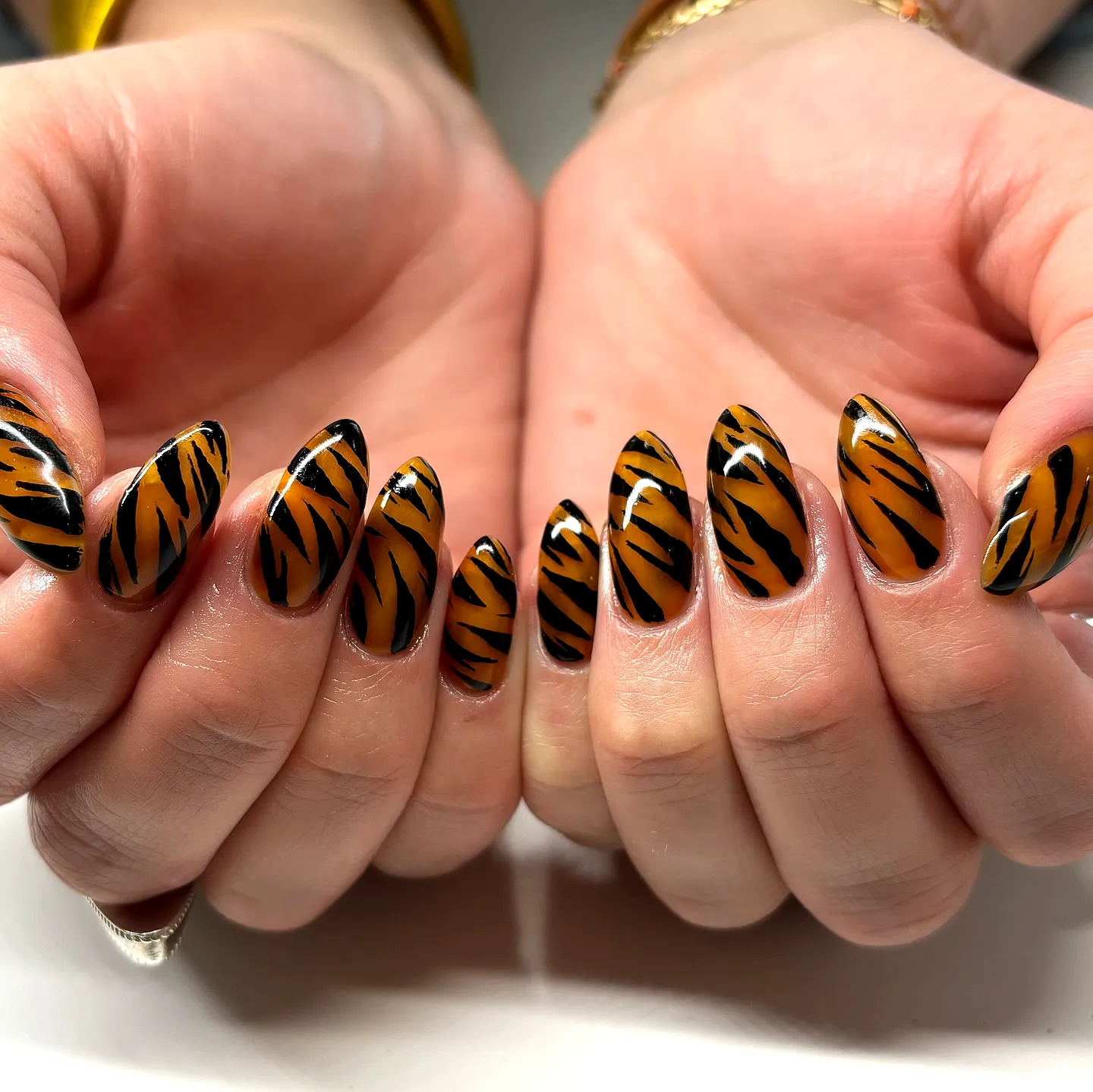 Fierce Orange Almond-Shaped Animal Print Nails with Bold Black Tiger Stripes