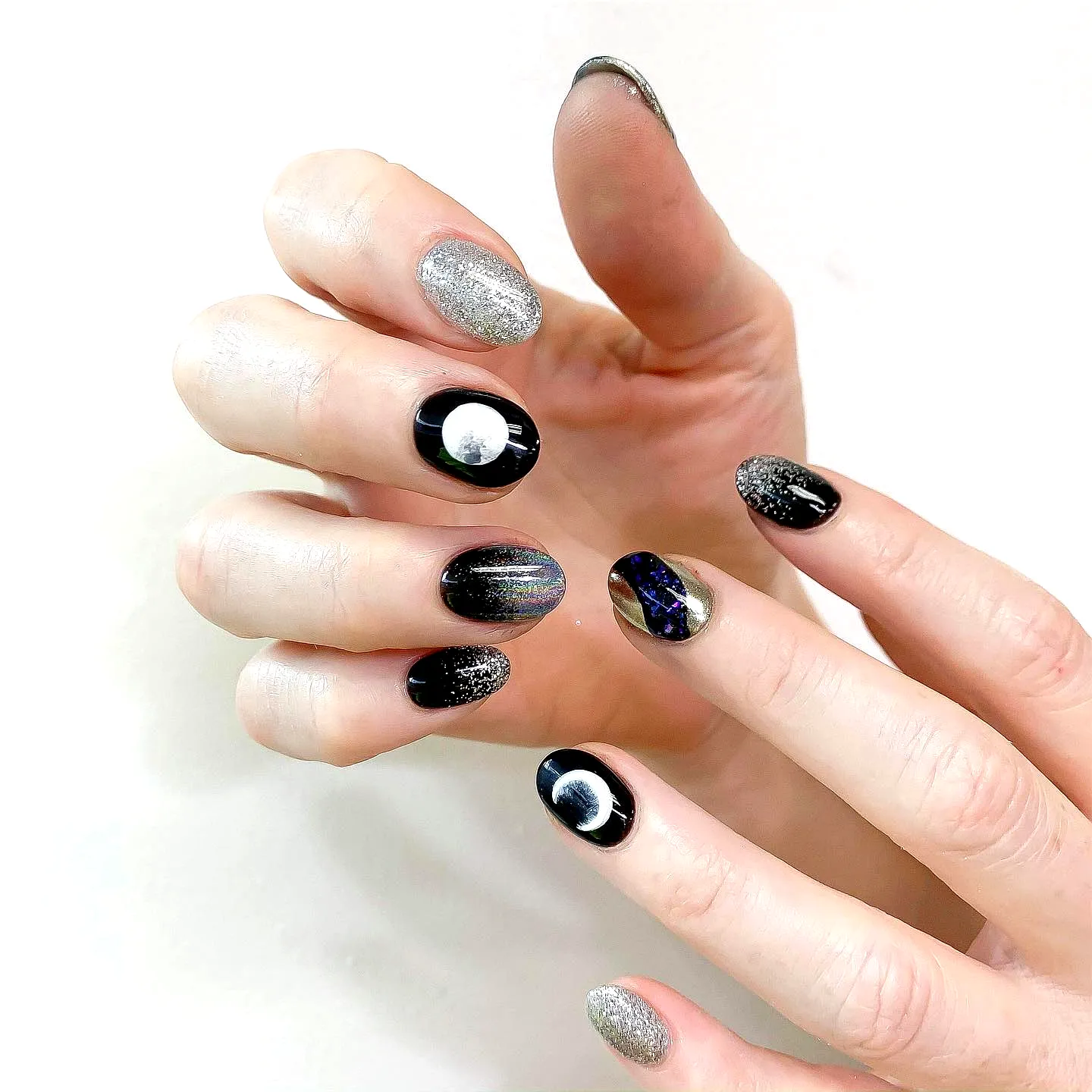 Glamorous Almond Half-Moon Nails with Black and Silver Shades Featuring Celestial Accents