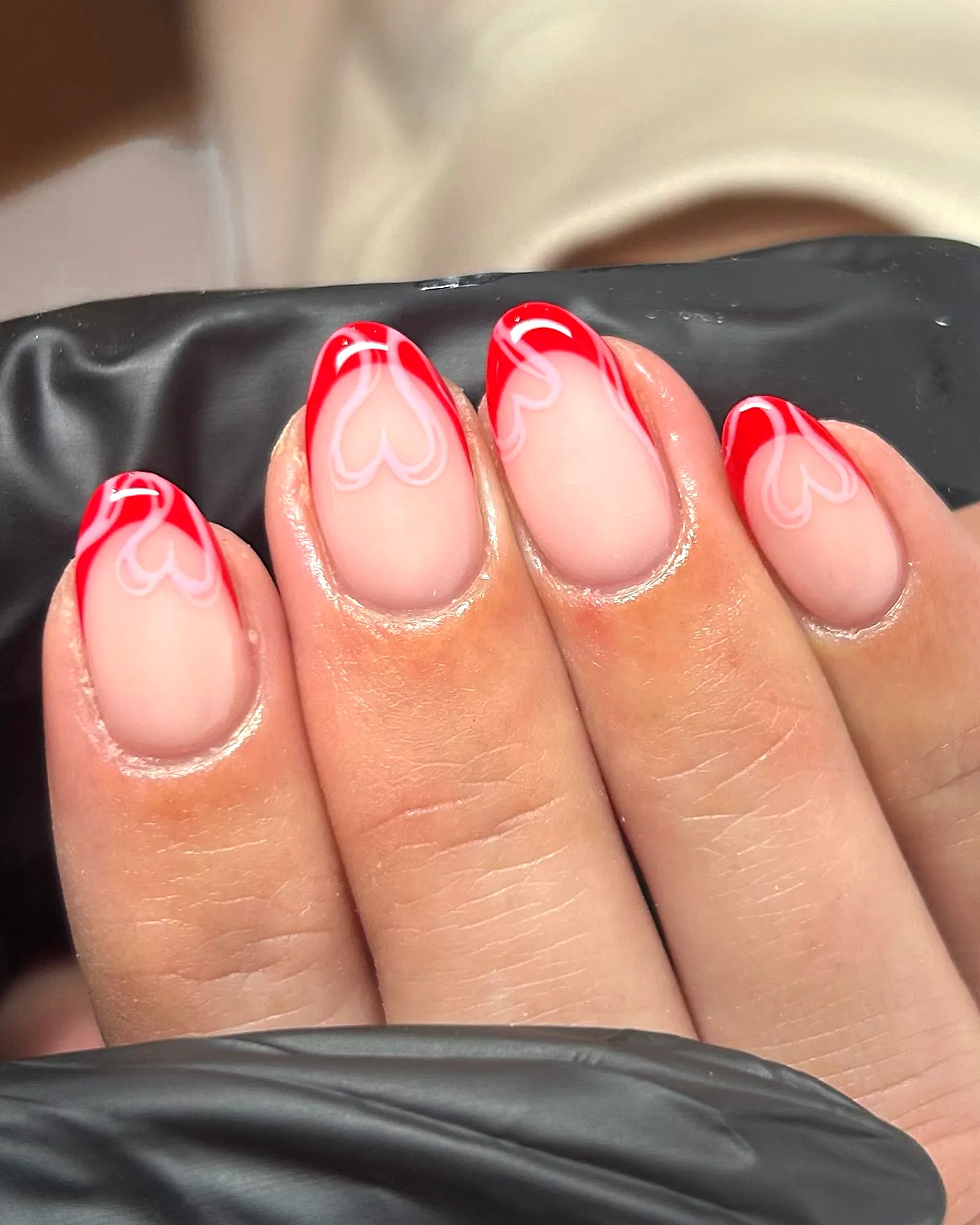 Playful Almond Shaped French Heart Nails with Soft Nude Base and Glossy Finish