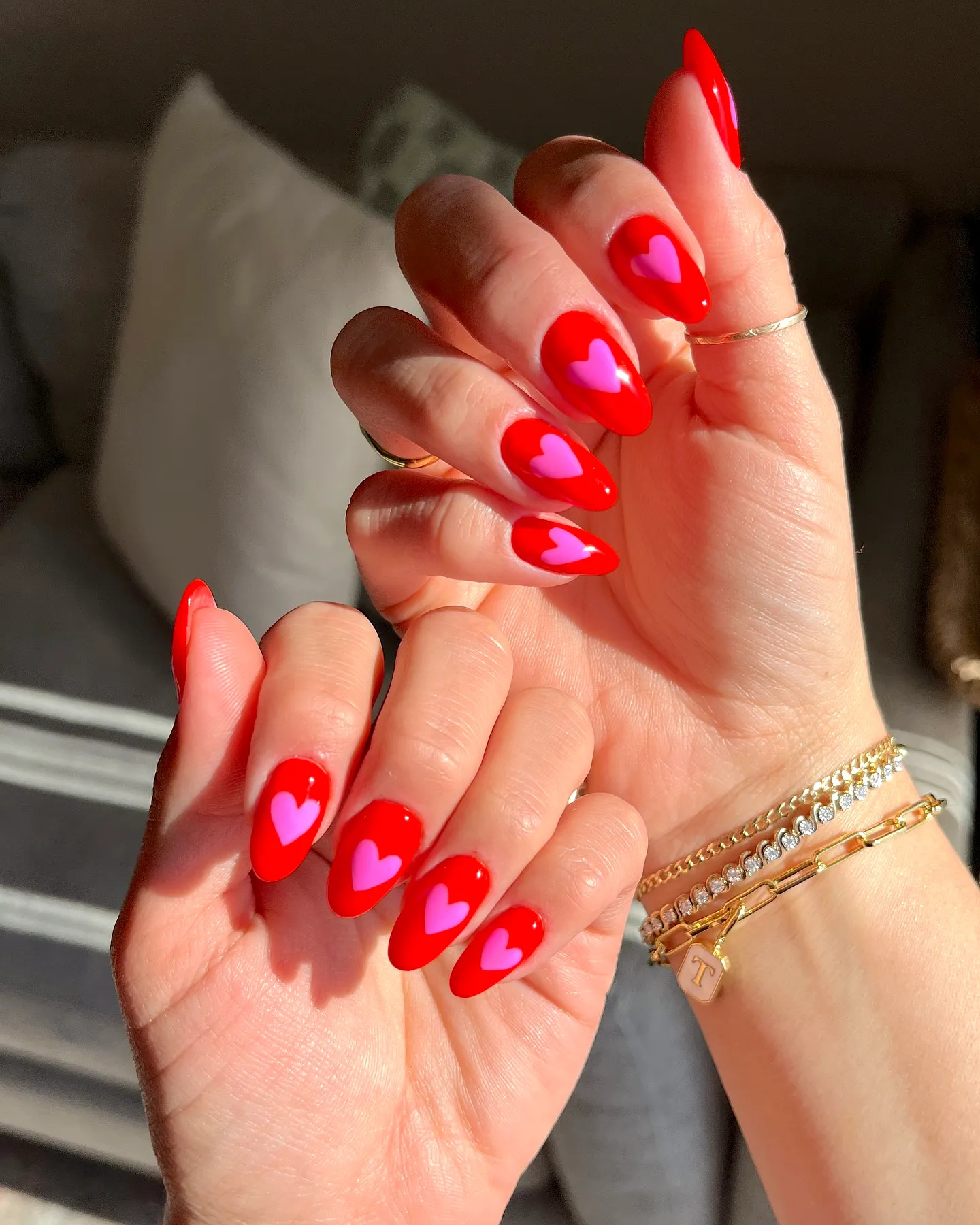 Romantic Almond-Shaped Valentines Day Nails in Glossy Bright Red with Cute Light Pink Heart Patterns