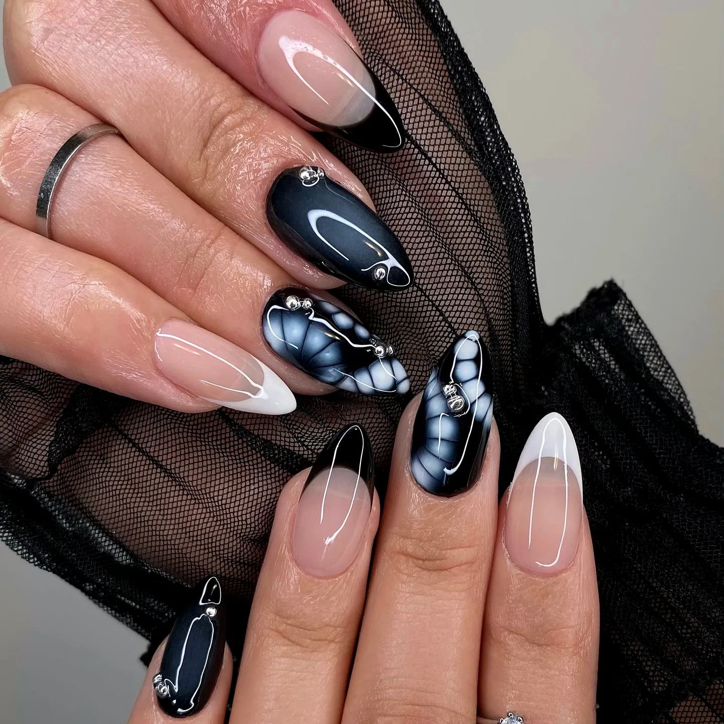 Sophisticated Black Nails with Stiletto and Almond Shapes Featuring Intricate Patterns and Elegant Gemstone Accents