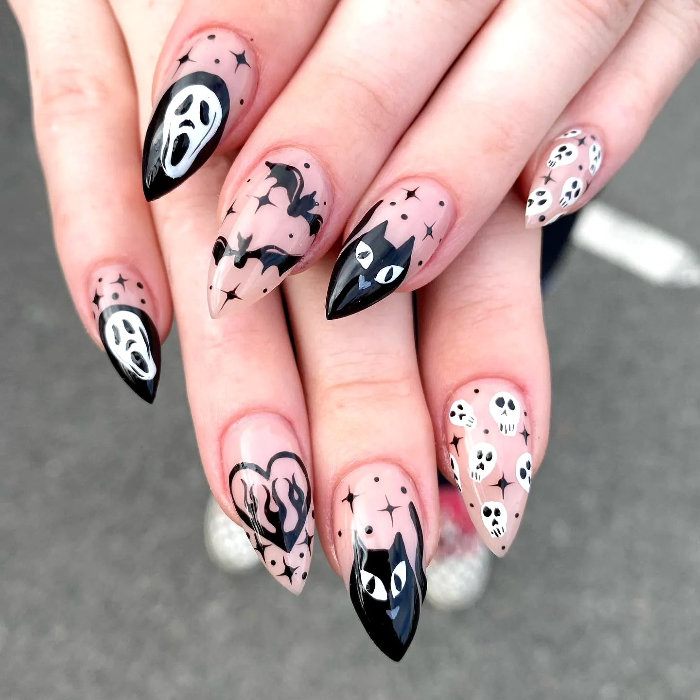Spooky Black Cat Nails with Stiletto Shape Featuring Ghostly Faces Bats and Skulls in Black and White