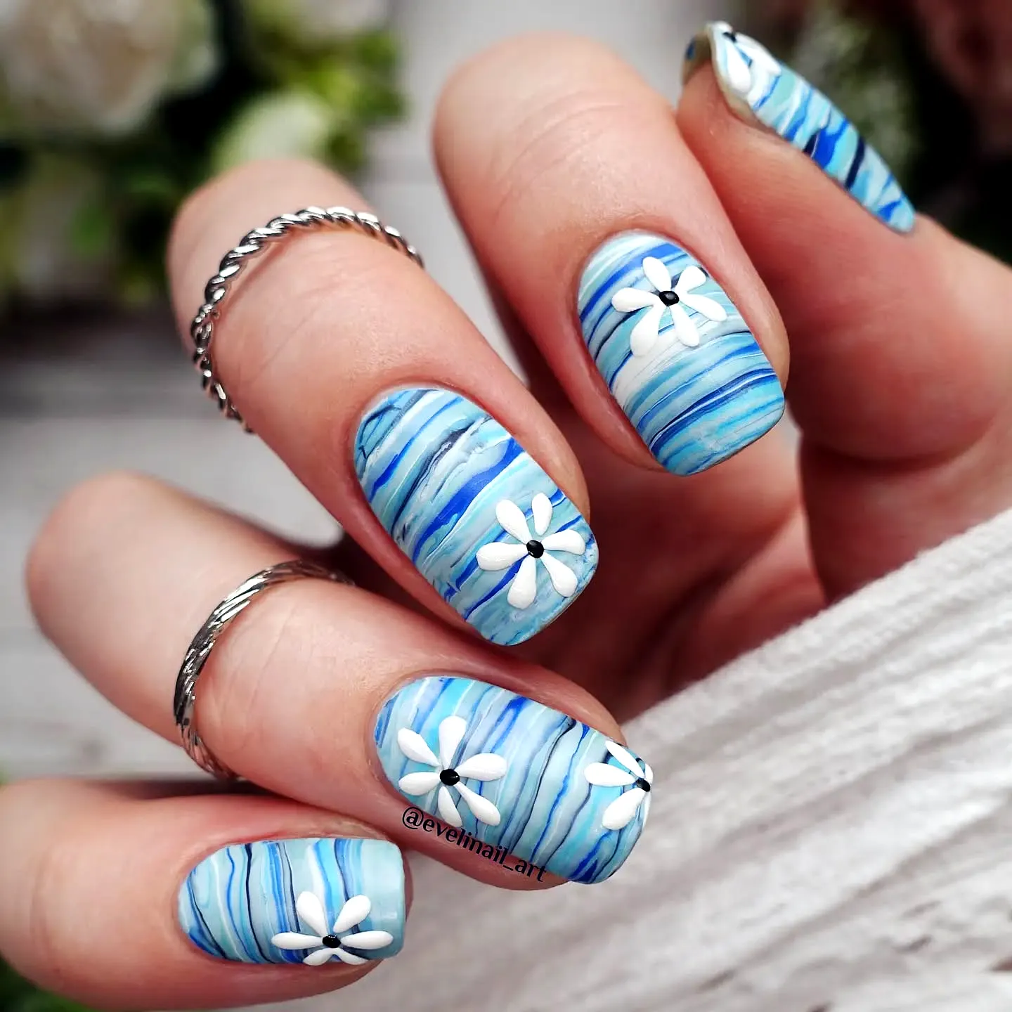 Striped Nails in Almond Shape Showcasing Blue Tones and Floral Nail Art Style
