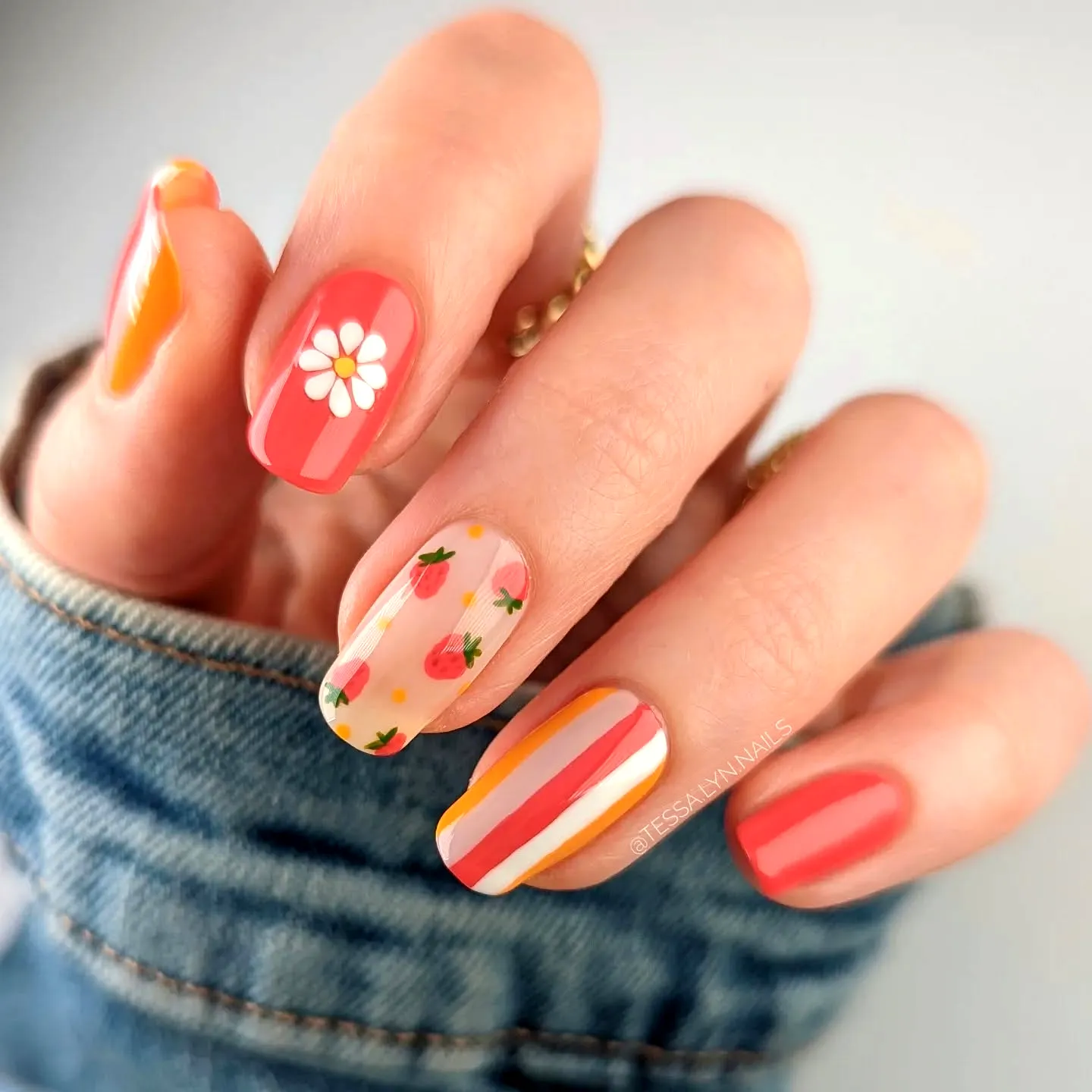 Striped Nails in Coral and Peach Shades with Floral and Strawberry Motifs on Squared Off Tips