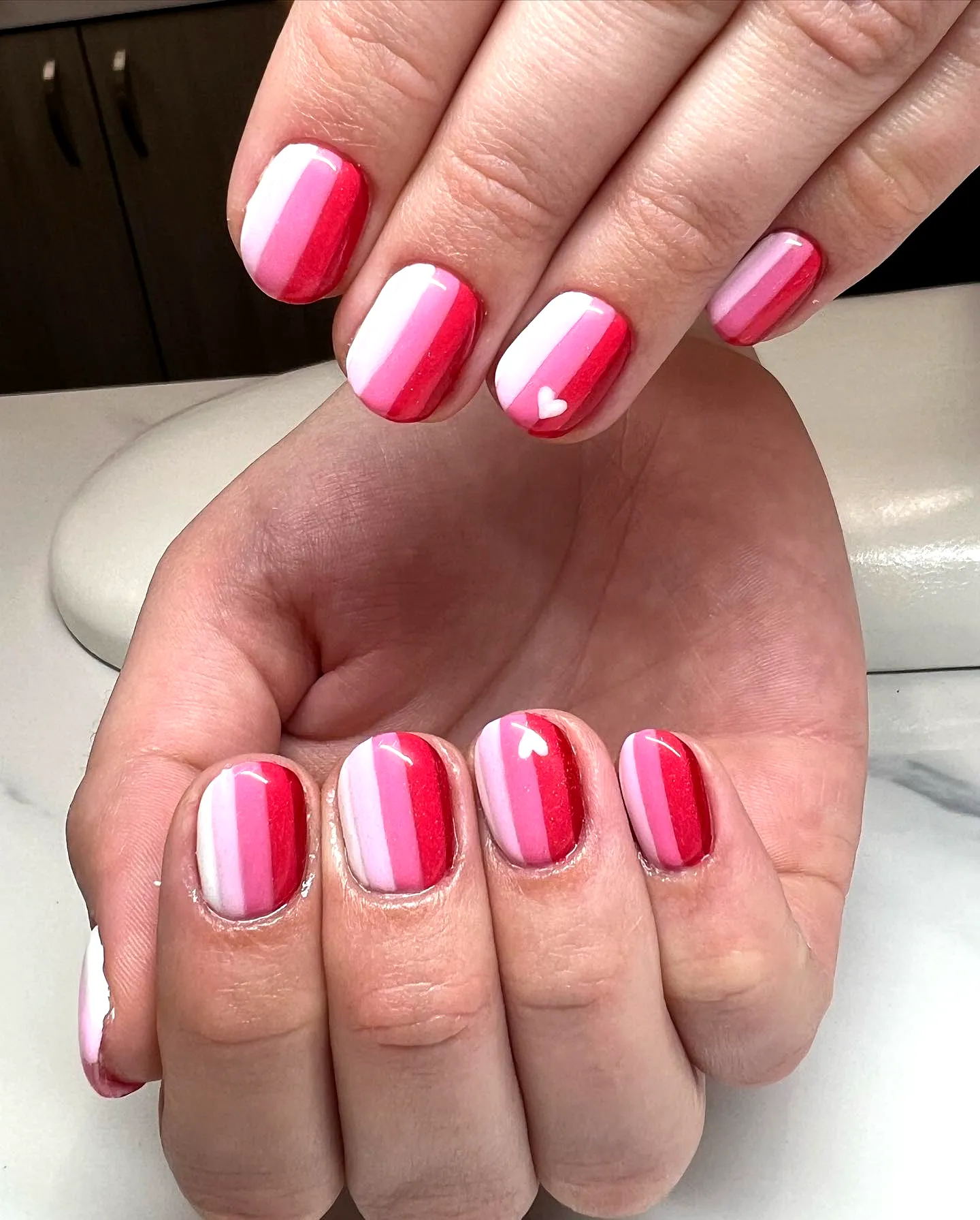 Striped Nails in Glossy Red and Pink Oval Shape with Playful Heart Design