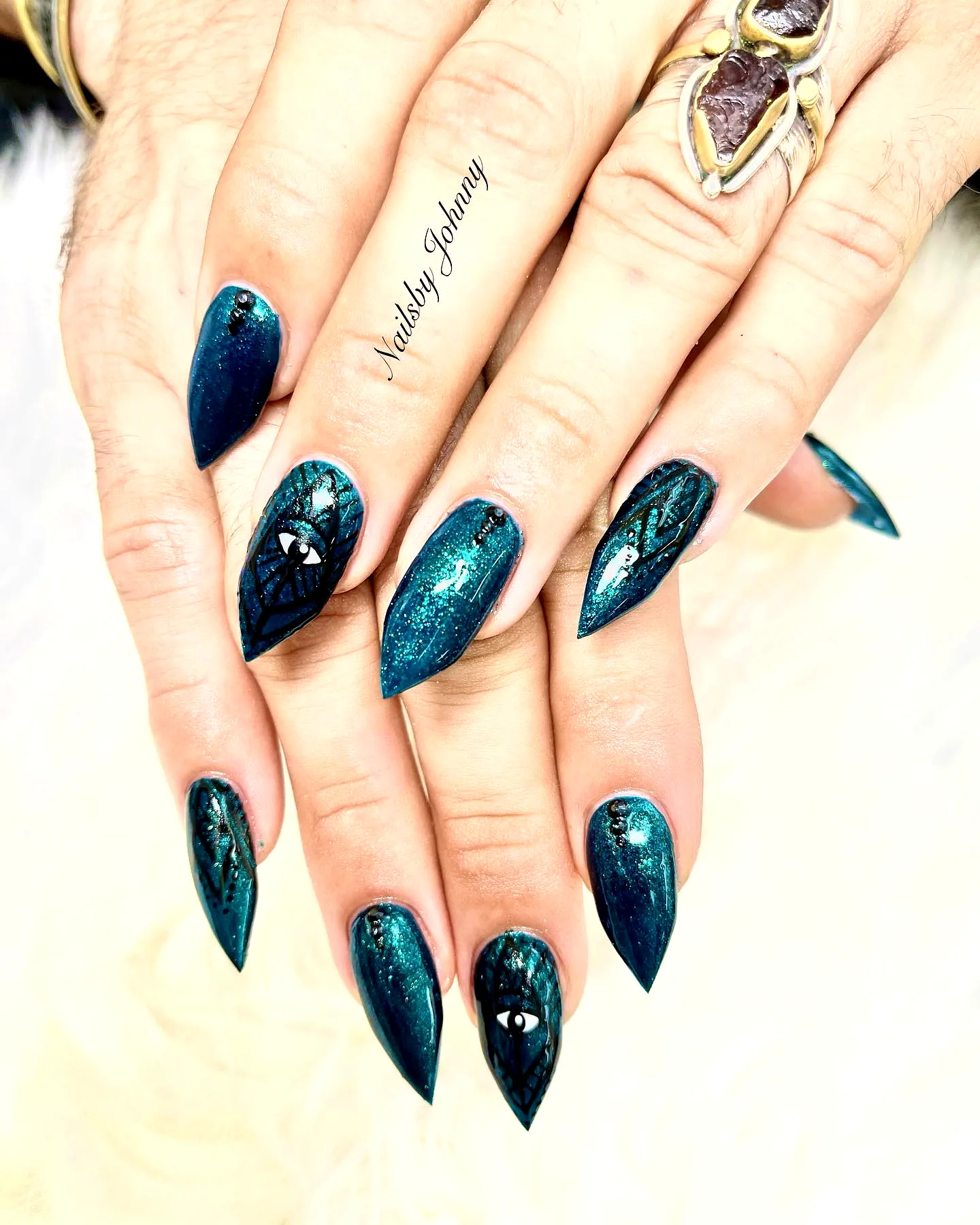Stunning Almond-Shaped Arrowhead Nails in Teal with Intricate Geometric Patterns and Sparkling Embellishments