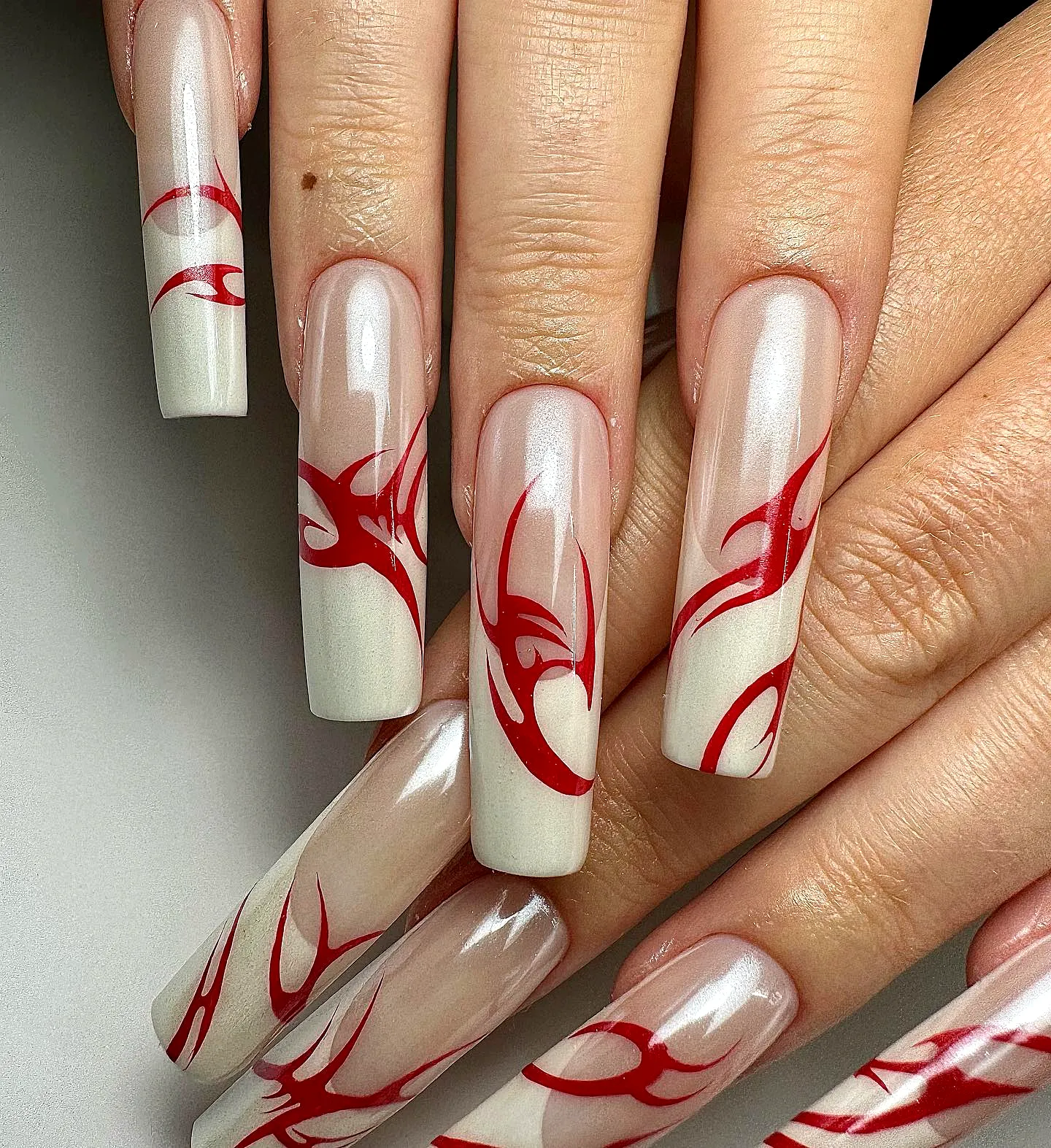 Stunning Long Square Tribal Nails with Nude Base and Bold Red Flame Patterns