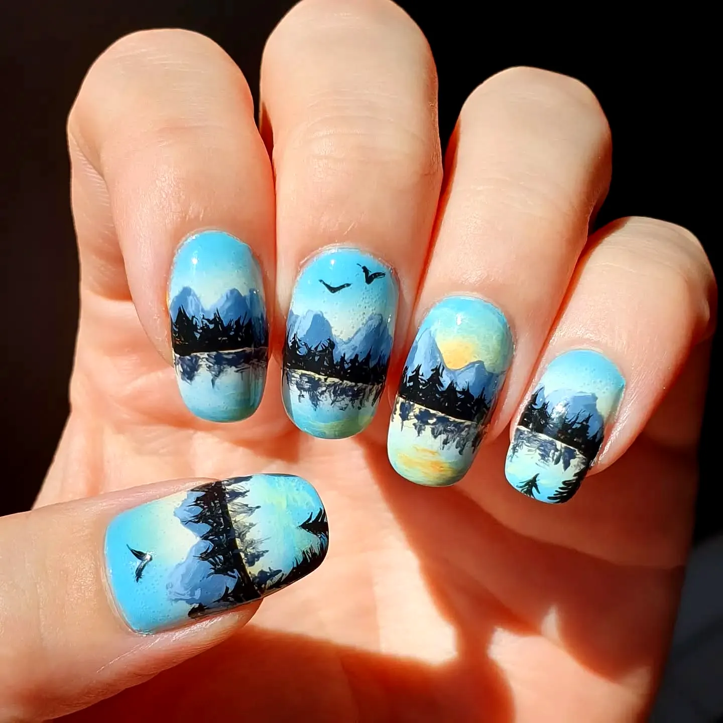 Stunning Rounded Mountain Nails with Serene Lake Scene in Vibrant Blue and Black