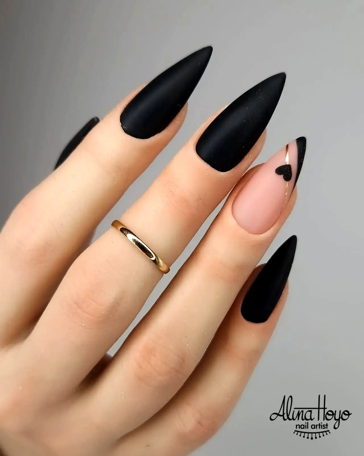 Stunning stiletto black nails with elegant heart accent nail design