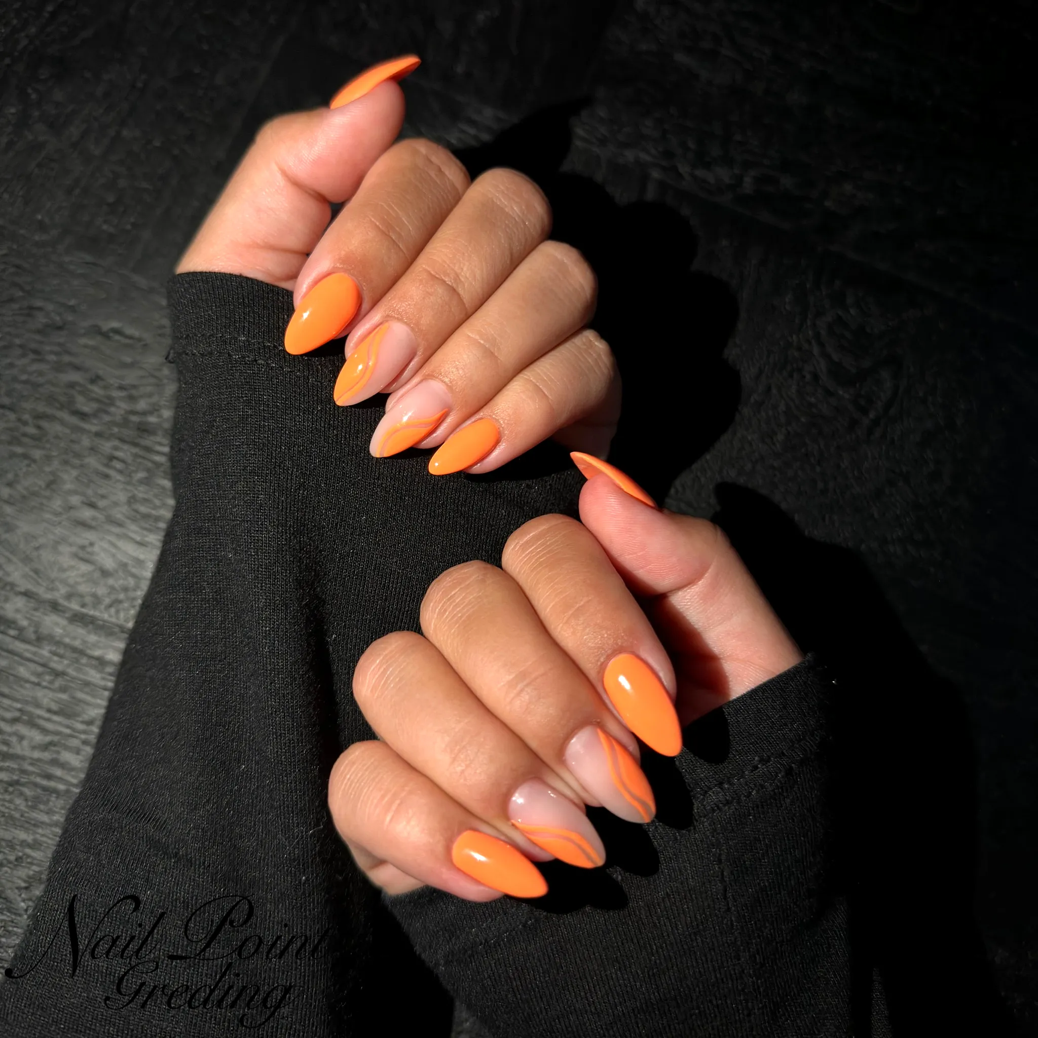 Vibrant Almond Shaped Orange Nails with Chic Nude Accents