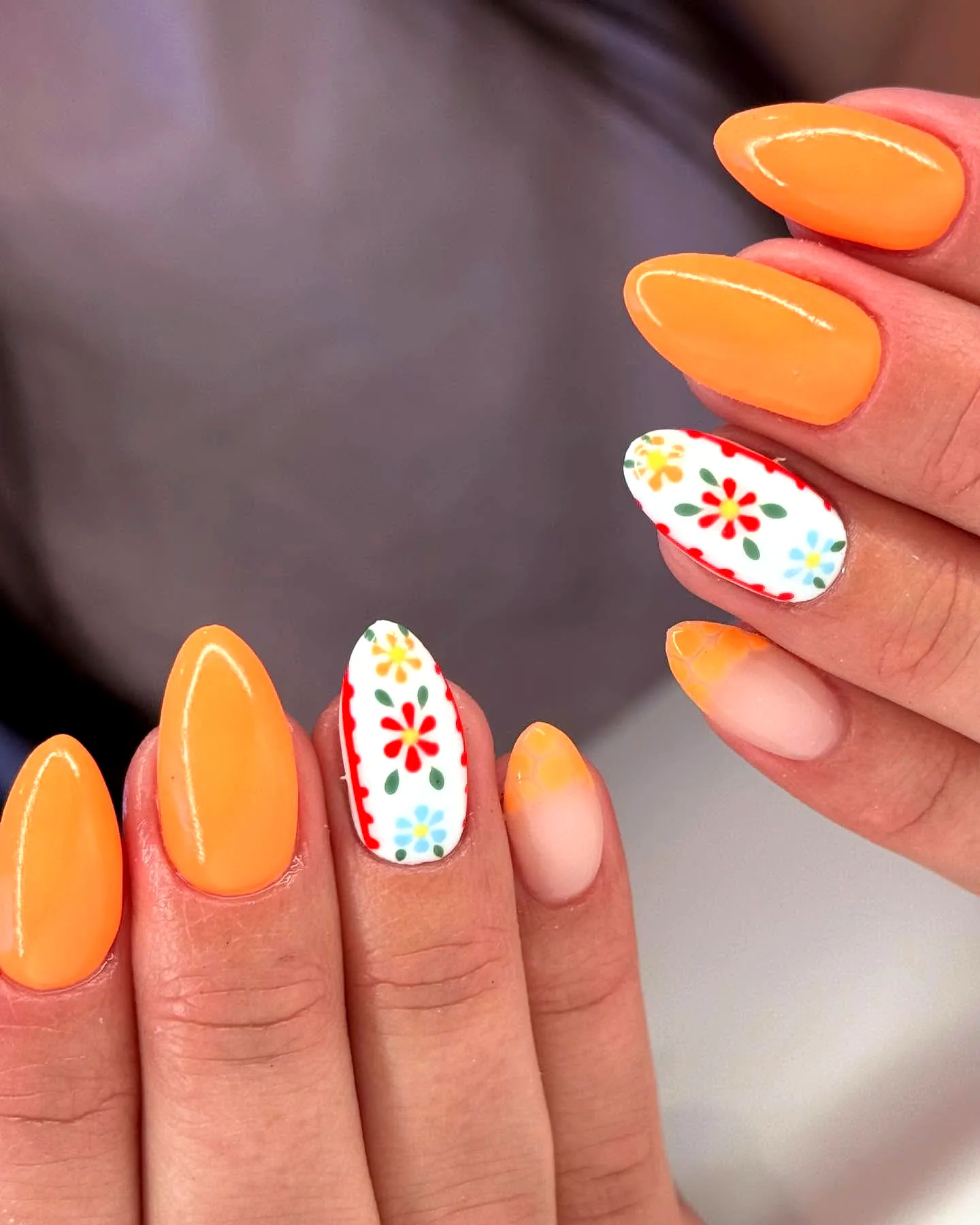 Vibrant Almond Shaped Orange Nails with Playful Floral Patterns and Geometric Details