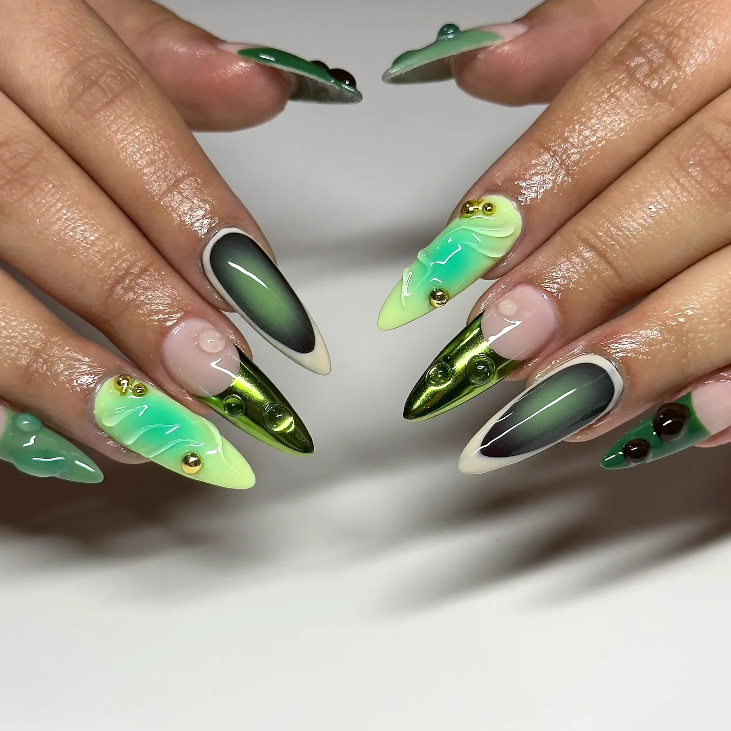 Vibrant Stiletto Green Nails Featuring Abstract Patterns and Glossy Finishes