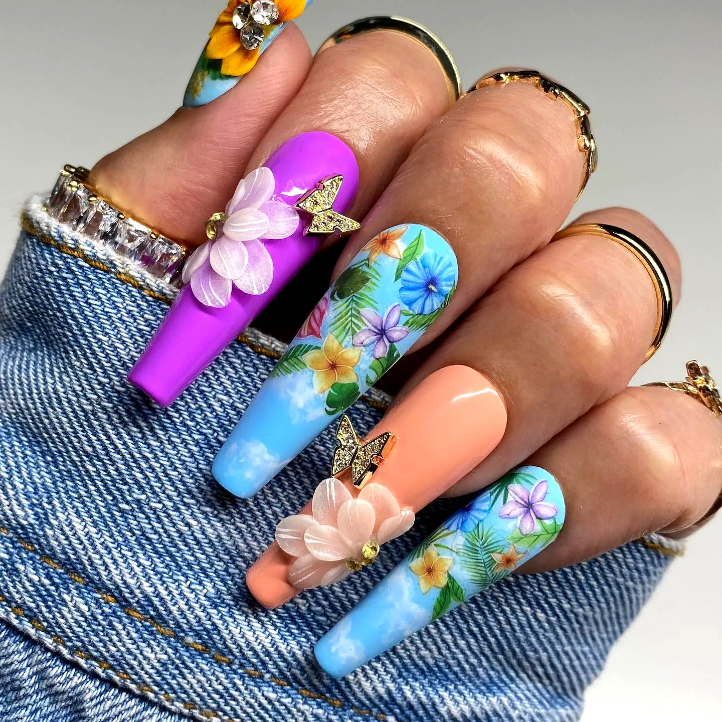 Vibrant Tropical Nail Designs with Floral Patterns on Long Stiletto Nails