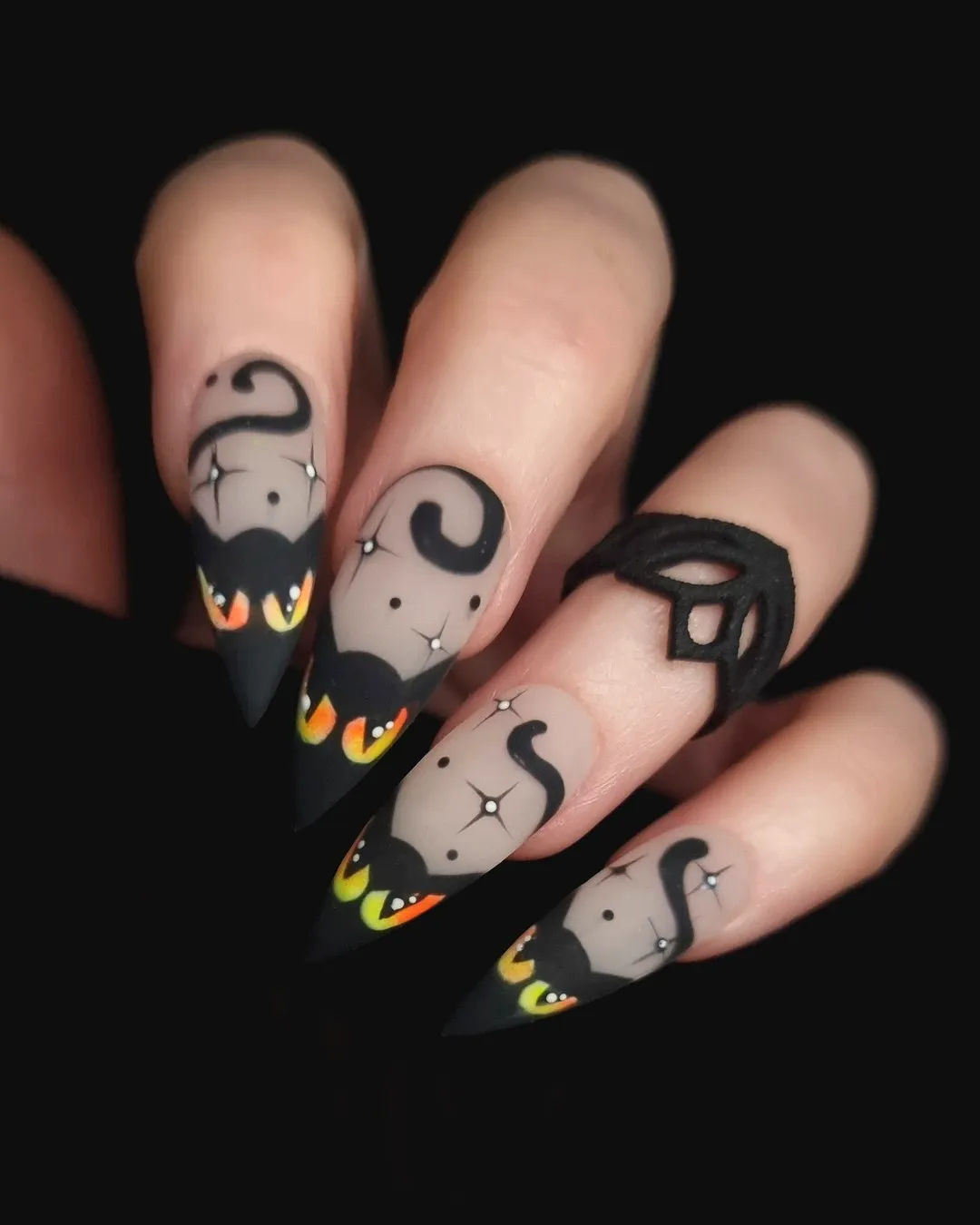 Whimsical Matte Black Stiletto Bat Nail Designs with Colorful Eyes and Flame Patterns