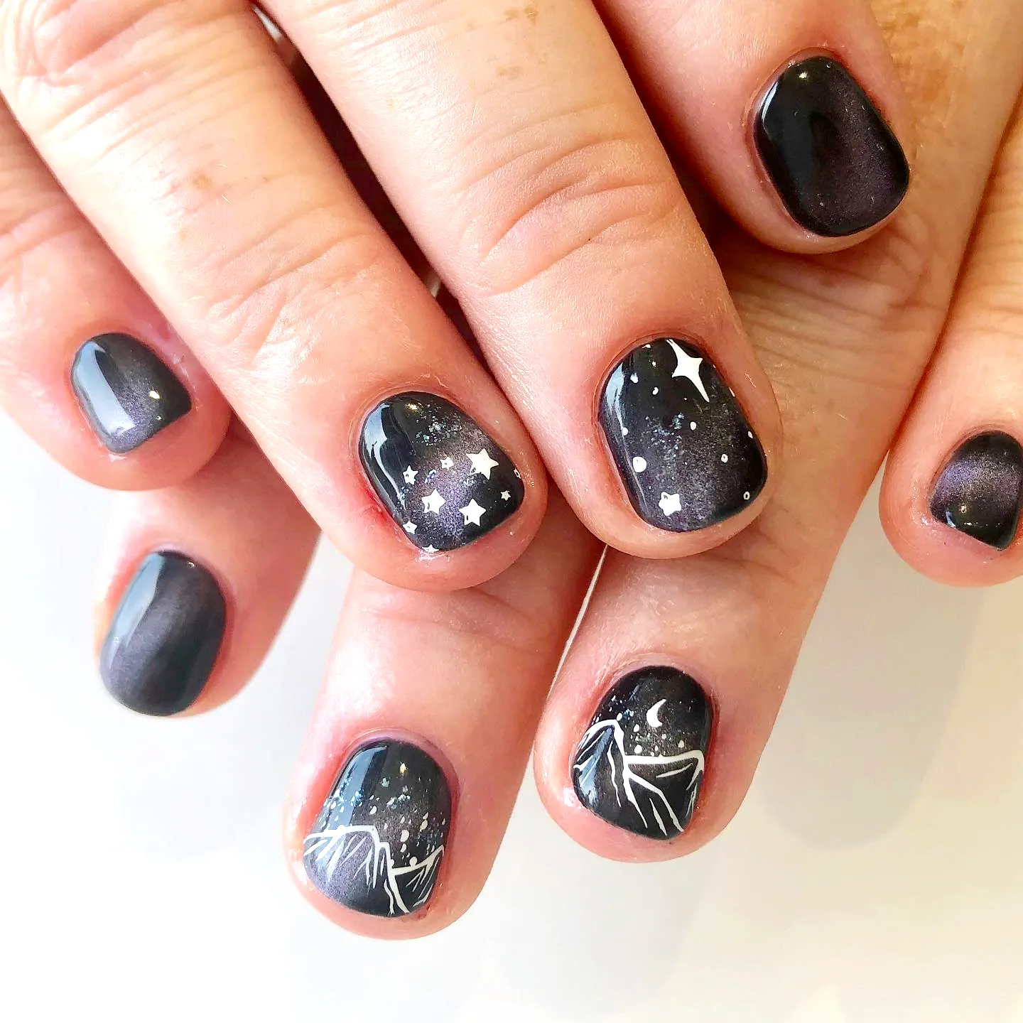 Whimsical Round Mountain Nails with Dark Starry Background and Hand-Painted White Silhouettes