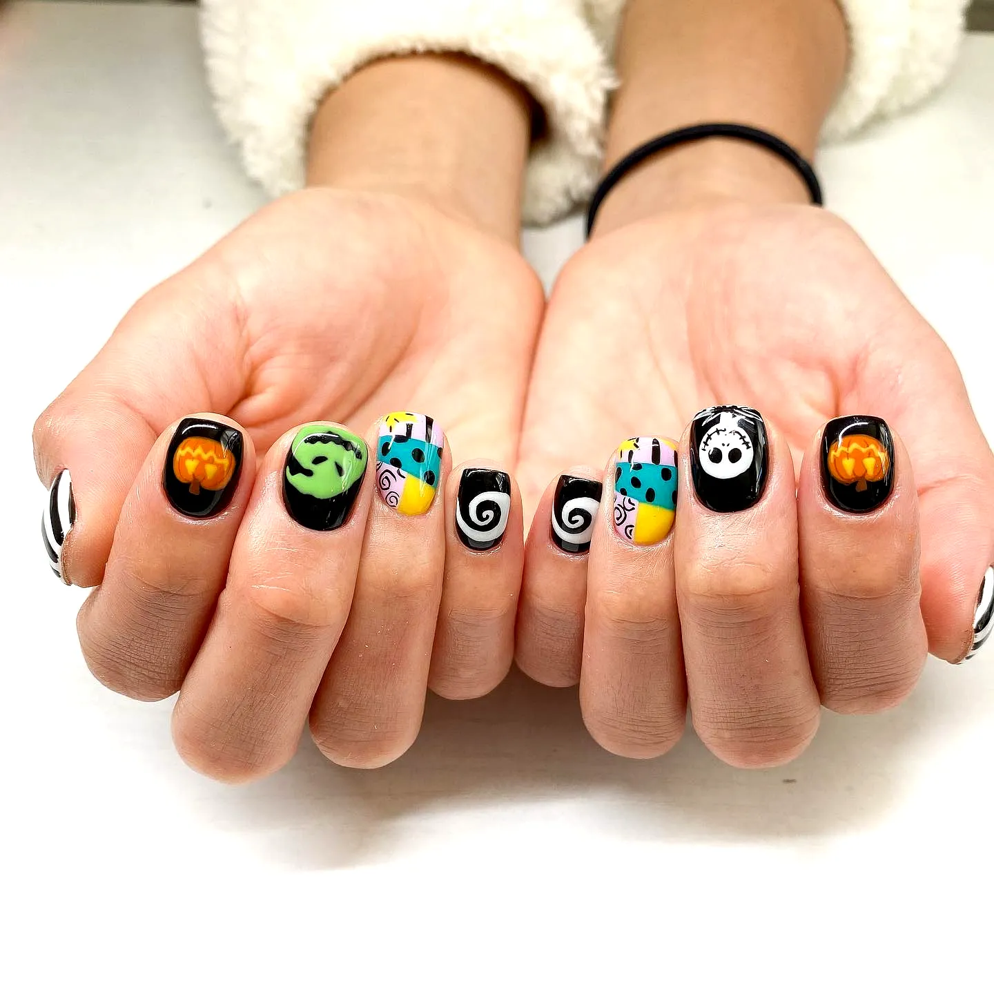 Whimsical Rounded Nightmare Before Christmas Nails with Colorful Patterns and Halloween Art