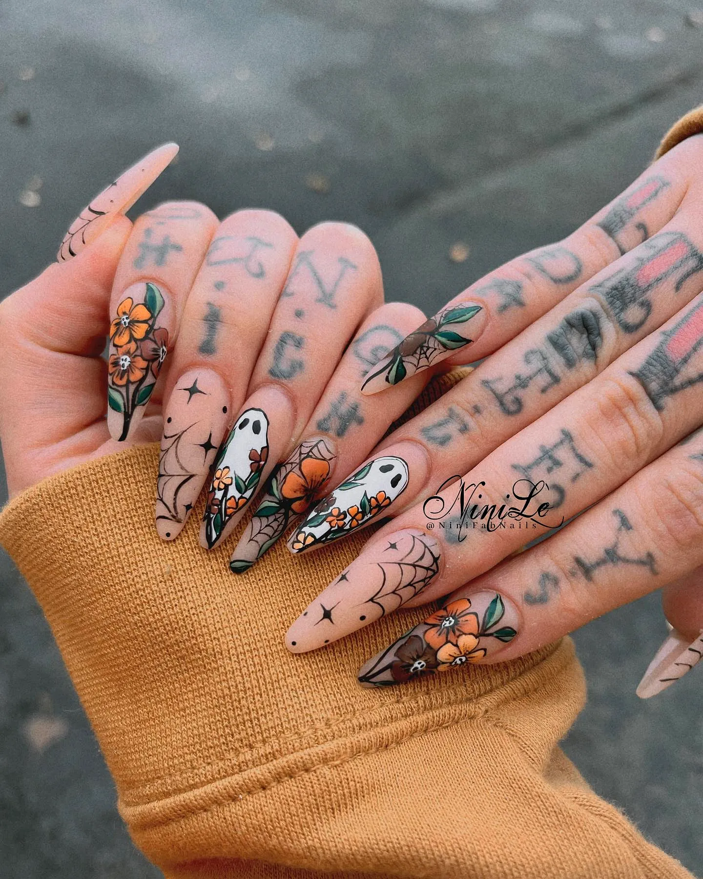 Whimsical Stiletto Fall Nail Designs Featuring Muted Tones Floral Patterns and Ghost Motifs